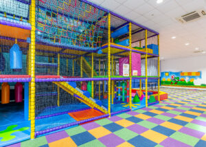 Children’s indoor soft play area at North Devon Resort, featuring a large multi-level climbing frame, slides, colourful play equipment and padded flooring.