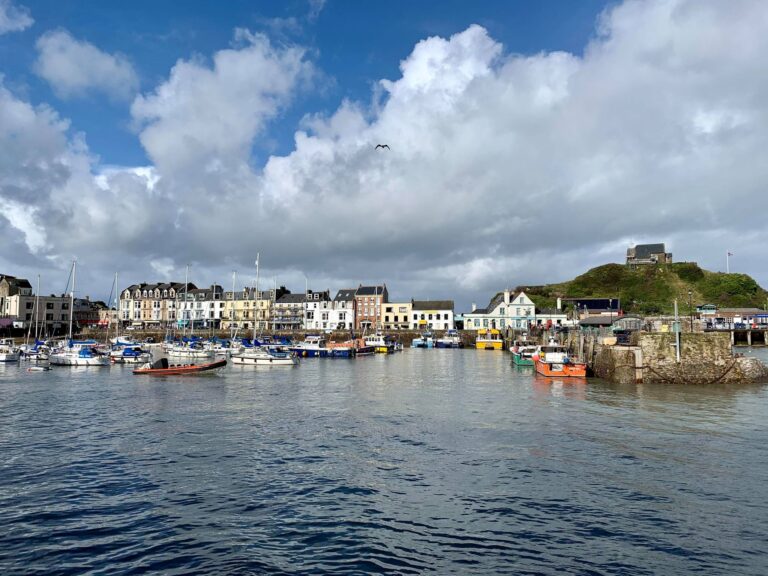 View of Ilfracombe Harbour on the North Devon coast with boats, coastline and town buildings in Devon